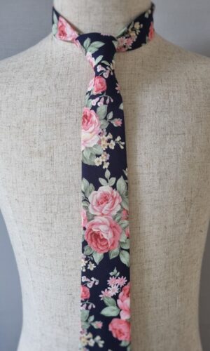 This tie boasts a mesmerizing floral print that will capture the attention of everyone you meet. With bold pink roses blossoming across the fabric, their beauty accentuated by a subtle touch of sage. With every glance, the intricate pattern dances before your eyes, telling a story of elegance and individuality. Indulge in the rich hues and artistic finesse of our handcrafted tie, made from the finest 100% cotton fabric. Feel confident as you don this handmade accessory, knowing that its exceptional craftsmanship reflects your discerning taste. Allow the vibrant colors and captivating pattern to infuse your ensemble with character and flair. With this tie, your outfit becomes a walking work of art, effortlessly exuding style and sophistication. It's a statement piece that guarantees attention and admiration wherever you go, from important business meetings to elegant soirées. Immerse yourself in the world of endless possibilities as you explore the boundless versatility of this tie. Whether you pair it with a classic suit or elevate a casual outfit, the vivid colors and exquisite pattern will effortlessly elevate your entire look. Prepare to be showered with compliments, as this accessory becomes your secret weapon for making unforgettable impressions.