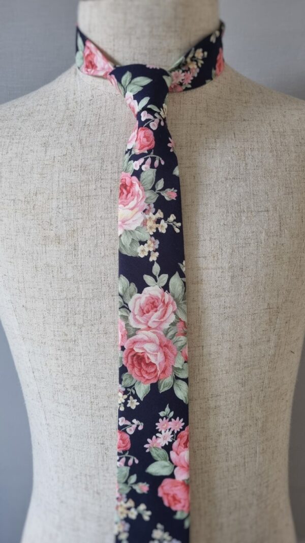 This tie boasts a mesmerizing floral print that will capture the attention of everyone you meet. With bold pink roses blossoming across the fabric, their beauty accentuated by a subtle touch of sage. With every glance, the intricate pattern dances before your eyes, telling a story of elegance and individuality. Indulge in the rich hues and artistic finesse of our handcrafted tie, made from the finest 100% cotton fabric. Feel confident as you don this handmade accessory, knowing that its exceptional craftsmanship reflects your discerning taste. Allow the vibrant colors and captivating pattern to infuse your ensemble with character and flair. With this tie, your outfit becomes a walking work of art, effortlessly exuding style and sophistication. It's a statement piece that guarantees attention and admiration wherever you go, from important business meetings to elegant soirées. Immerse yourself in the world of endless possibilities as you explore the boundless versatility of this tie. Whether you pair it with a classic suit or elevate a casual outfit, the vivid colors and exquisite pattern will effortlessly elevate your entire look. Prepare to be showered with compliments, as this accessory becomes your secret weapon for making unforgettable impressions.